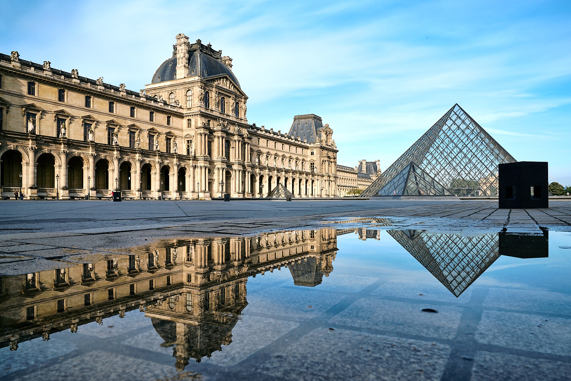 The Louvre Pyramid and Denon Wing facade reflected in the Cour Napoleon